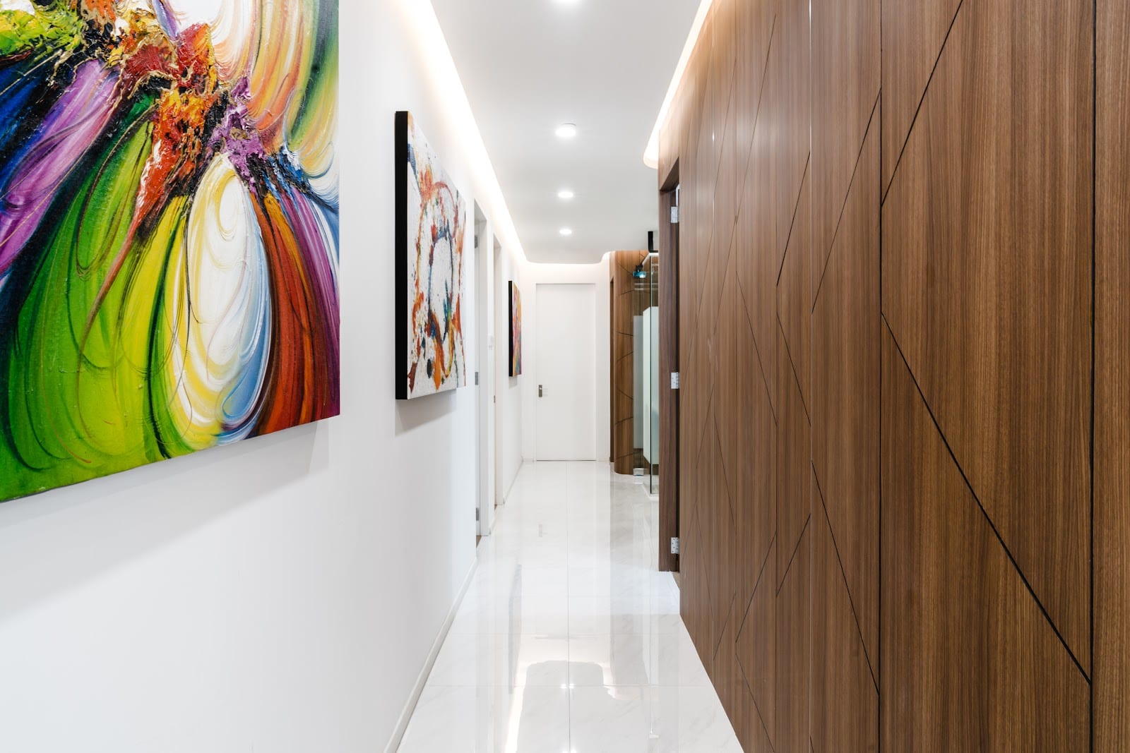 Private aesthetic treatment room with warm walnut fluting and ambient lighting